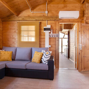 Casas Prefabricadas de Madera Chiclana - 2 dormitorios- 70 MM - 45 m2 - Modelo Kay - Cabaña de madera KAY - sofa y puerta